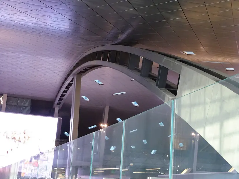 The curved ceiling and glass balustrade inside Hamad International Airport, Doha