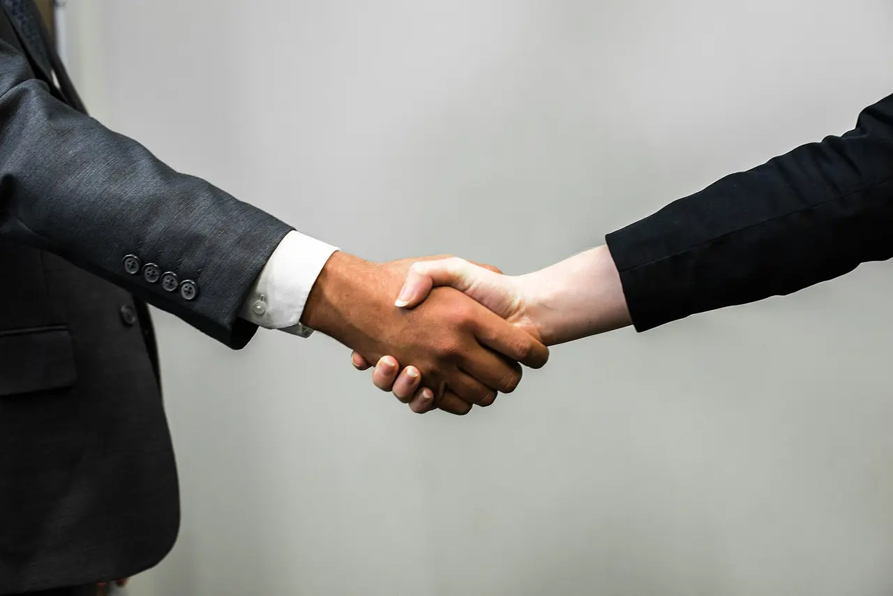 Two people in business suits shaking hands