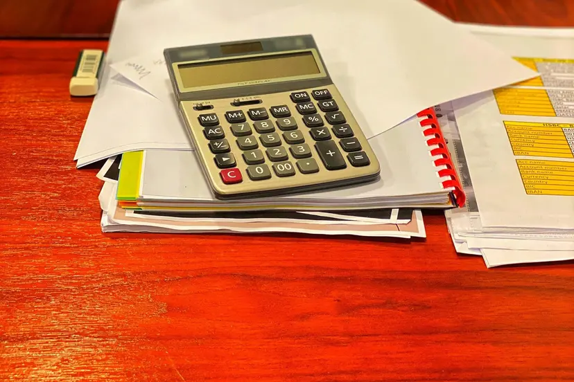 A calculator on a pile of papers on an office desk in Doha