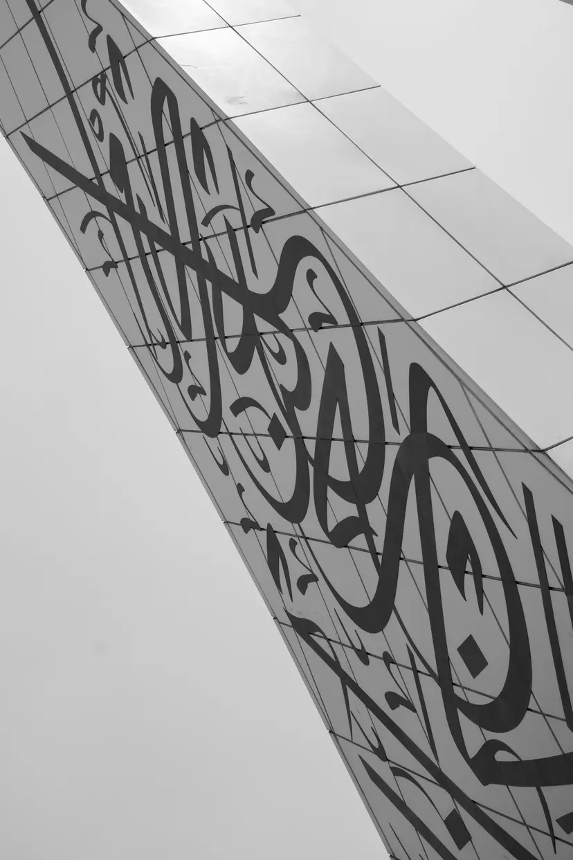Arabic calligraphy across a curved white facade in Doha