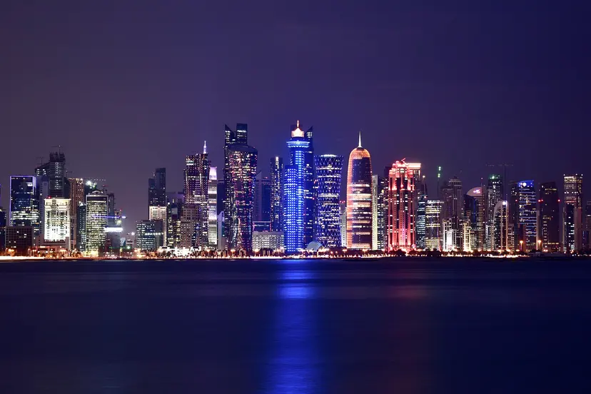 The West Bay skyline lit at night, seen across the water from the Corniche