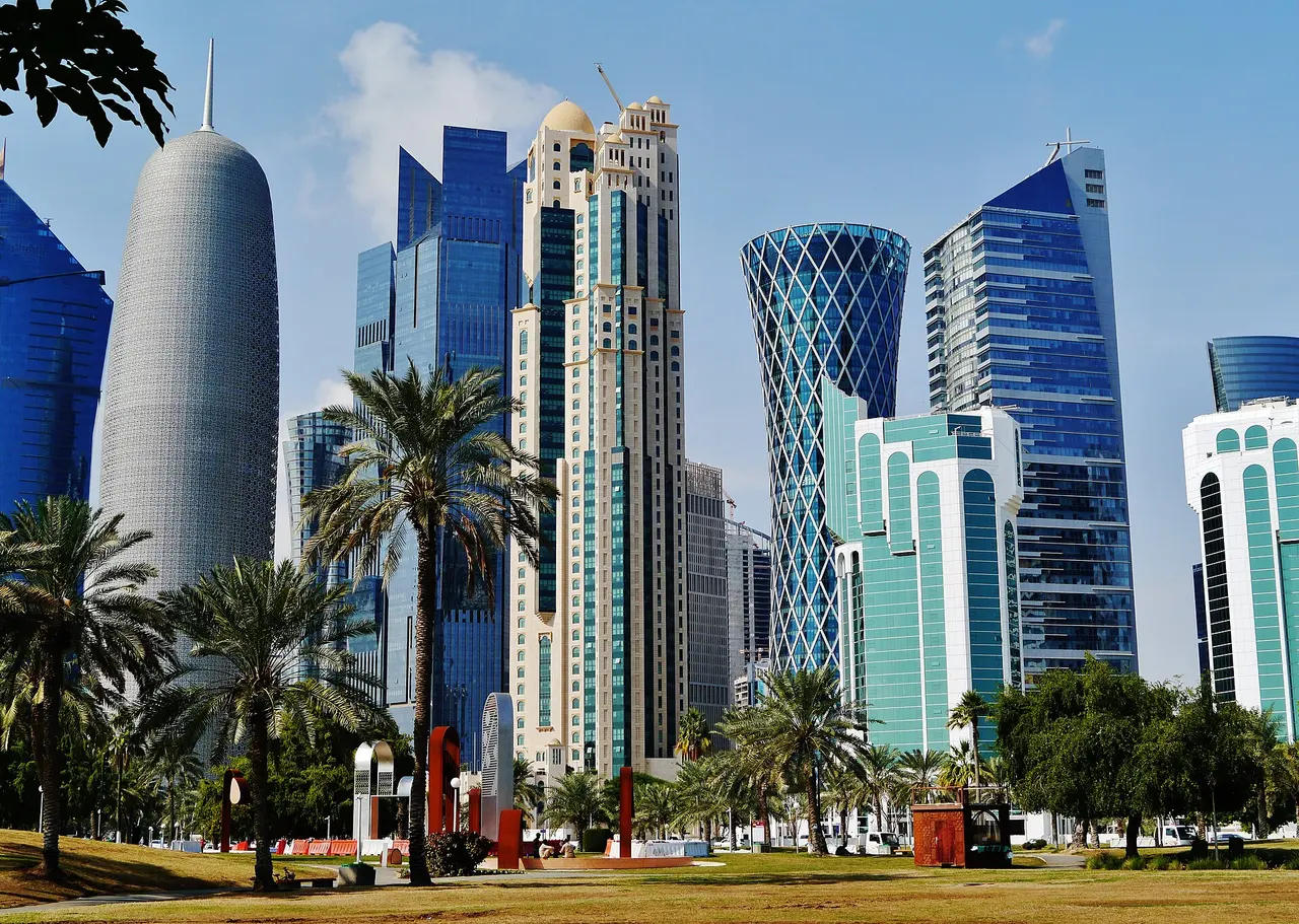 Glass towers of West Bay, Doha, with palm trees in front