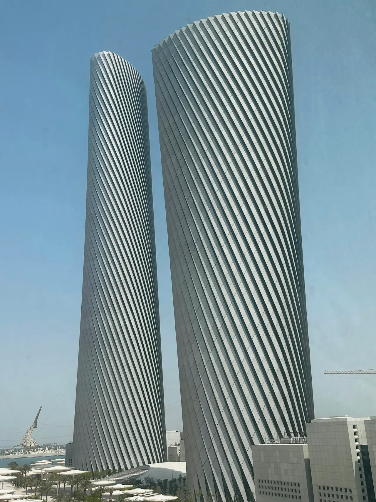 Two tall towers with diagonal fins against a clear sky in Lusail