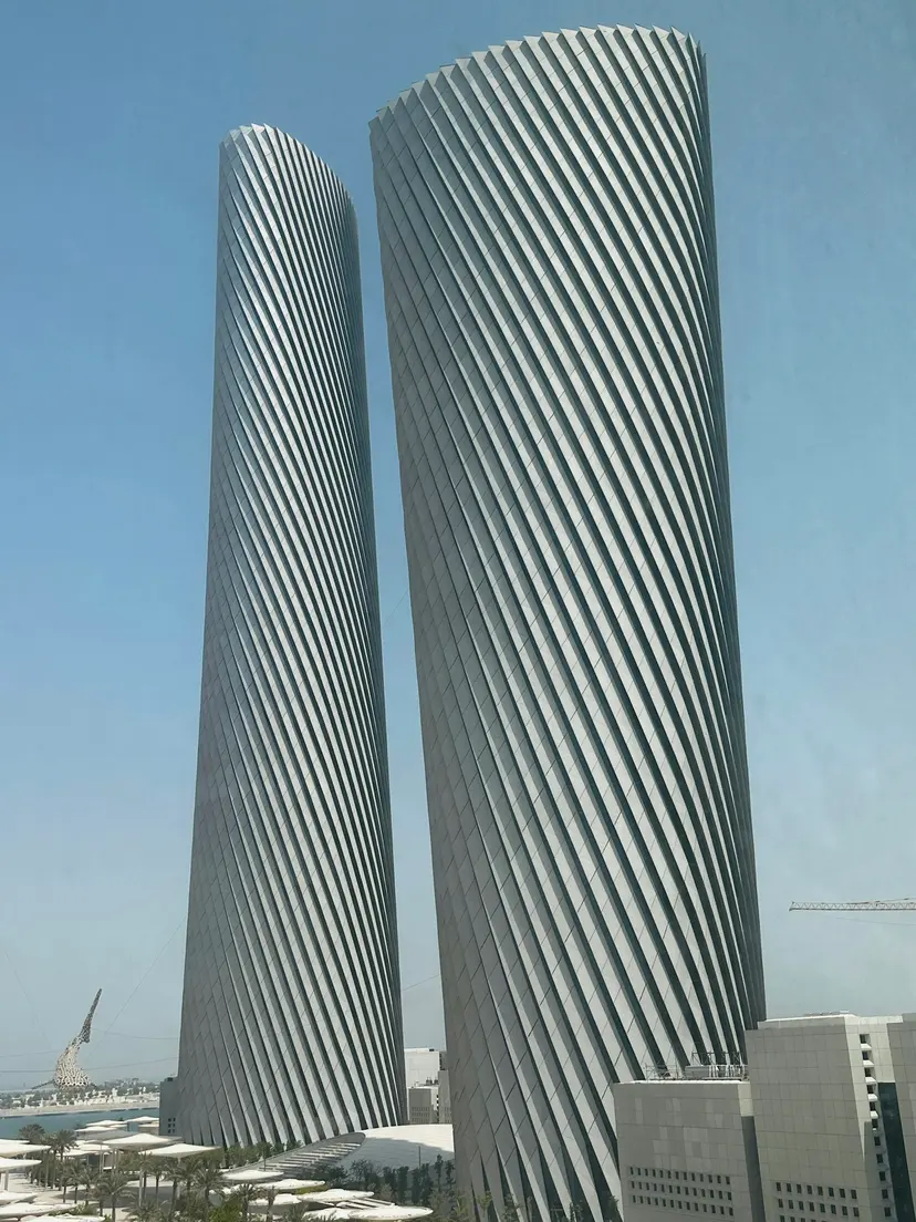 Two tall towers with diagonal fins against a clear sky in Lusail