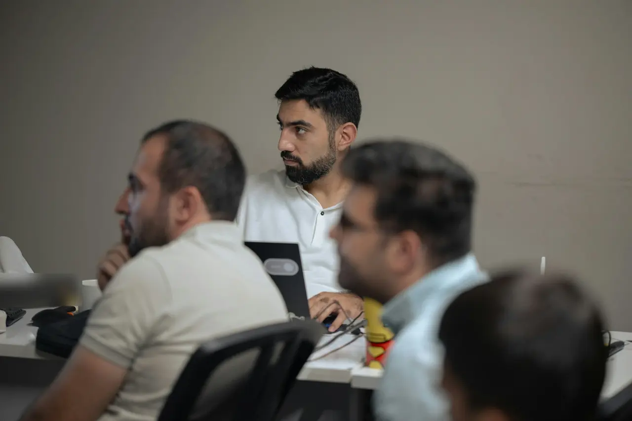 Staff listening during a training session at a meeting table