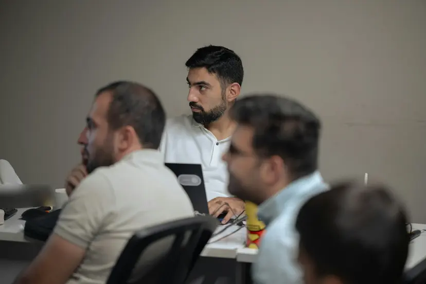 Staff listening during a training session at a meeting table