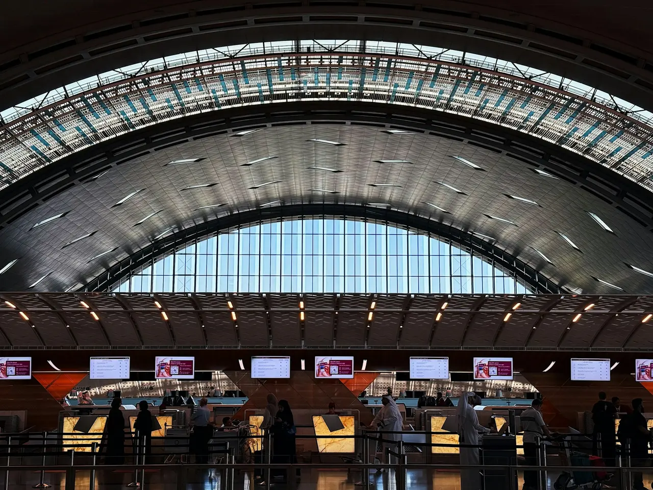 Check-in counters under the arched roof of Hamad International Airport