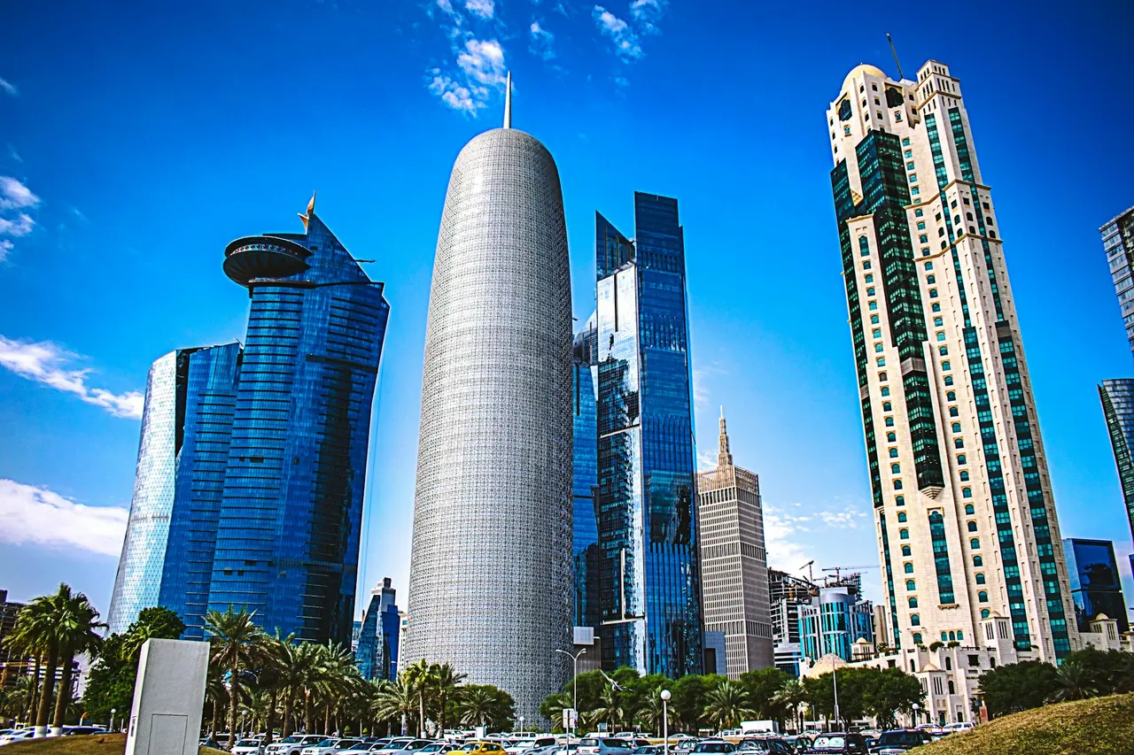 Office towers around Doha Tower in West Bay under a blue sky