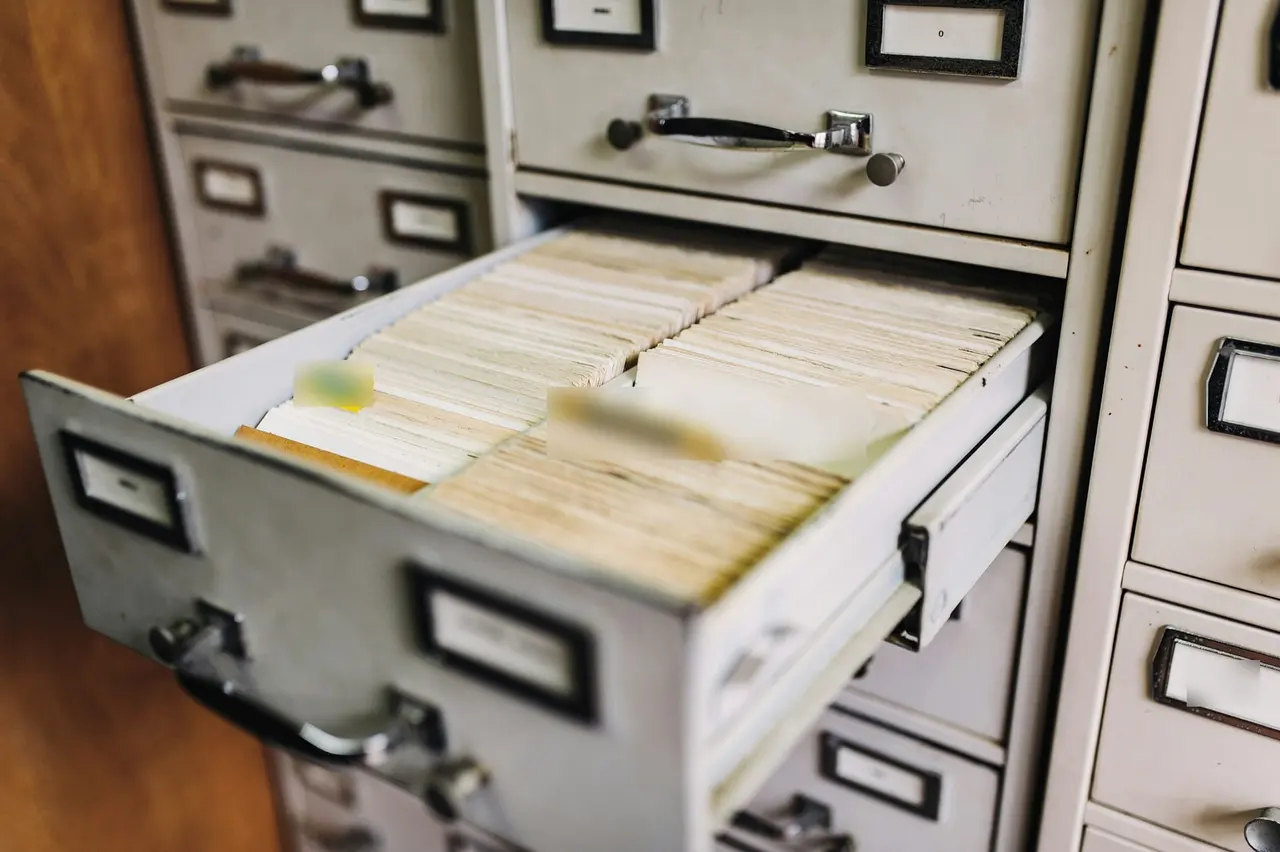 An open drawer of record cards in a metal filing cabinet