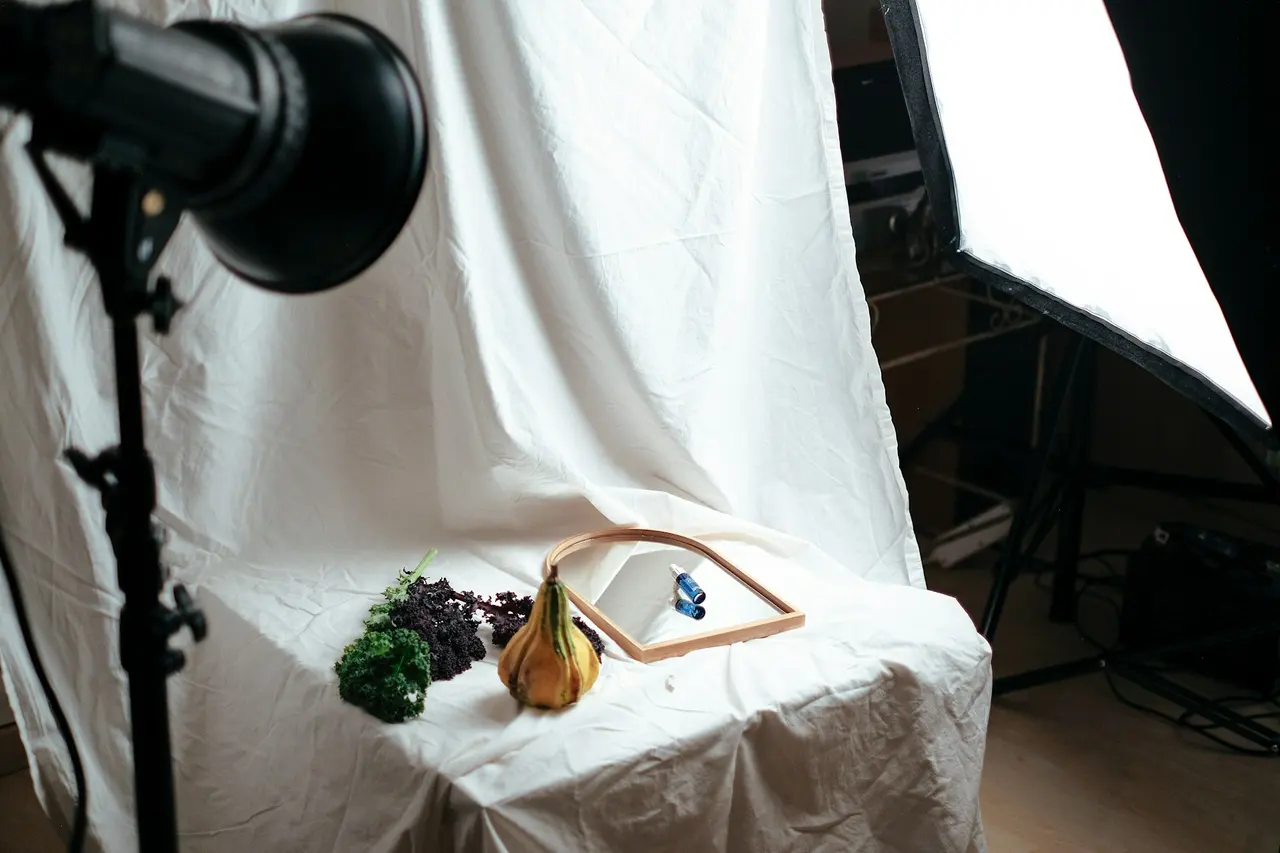 A product photography set with a white backdrop, studio lights and a small still life