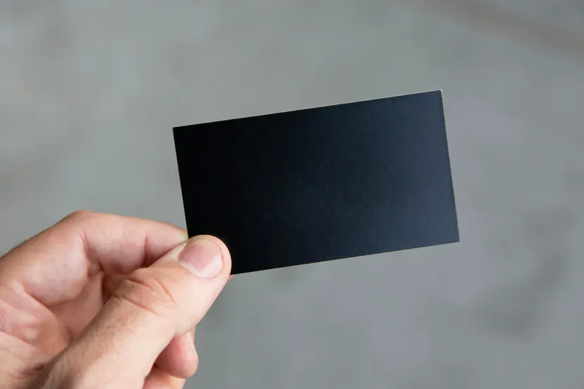 A hand holding a plain black card