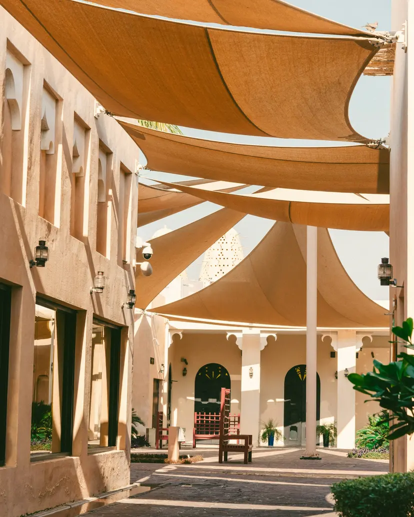 A shaded walkway between traditional shopfronts in Souq Waqif, Doha
