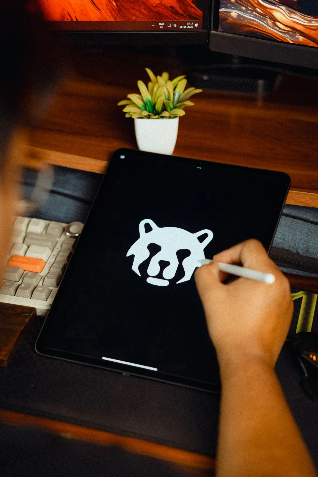 A designer drawing a logo on a tablet with a stylus