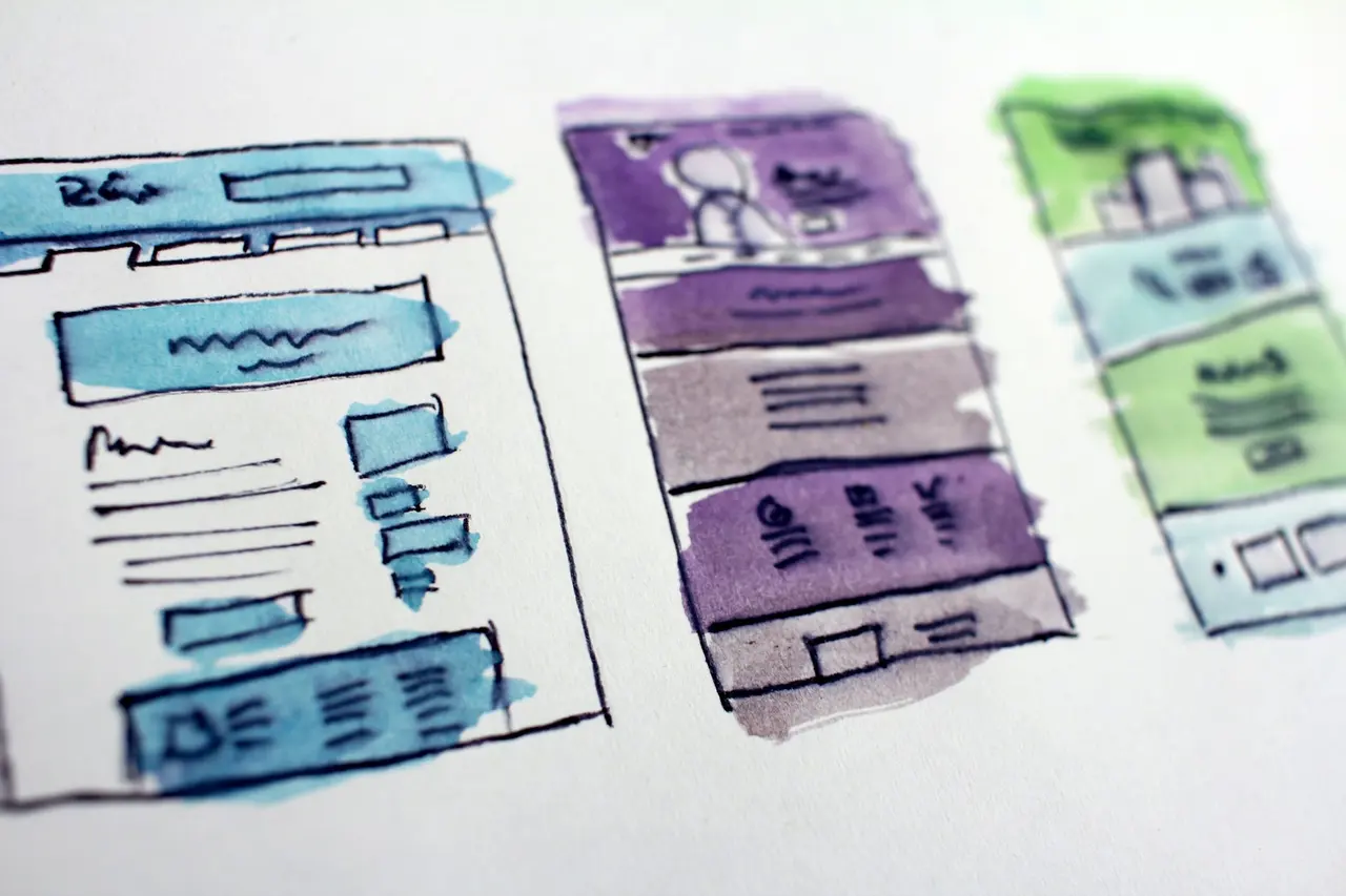 Watercolour wireframe sketches of website layouts for desktop and mobile screens